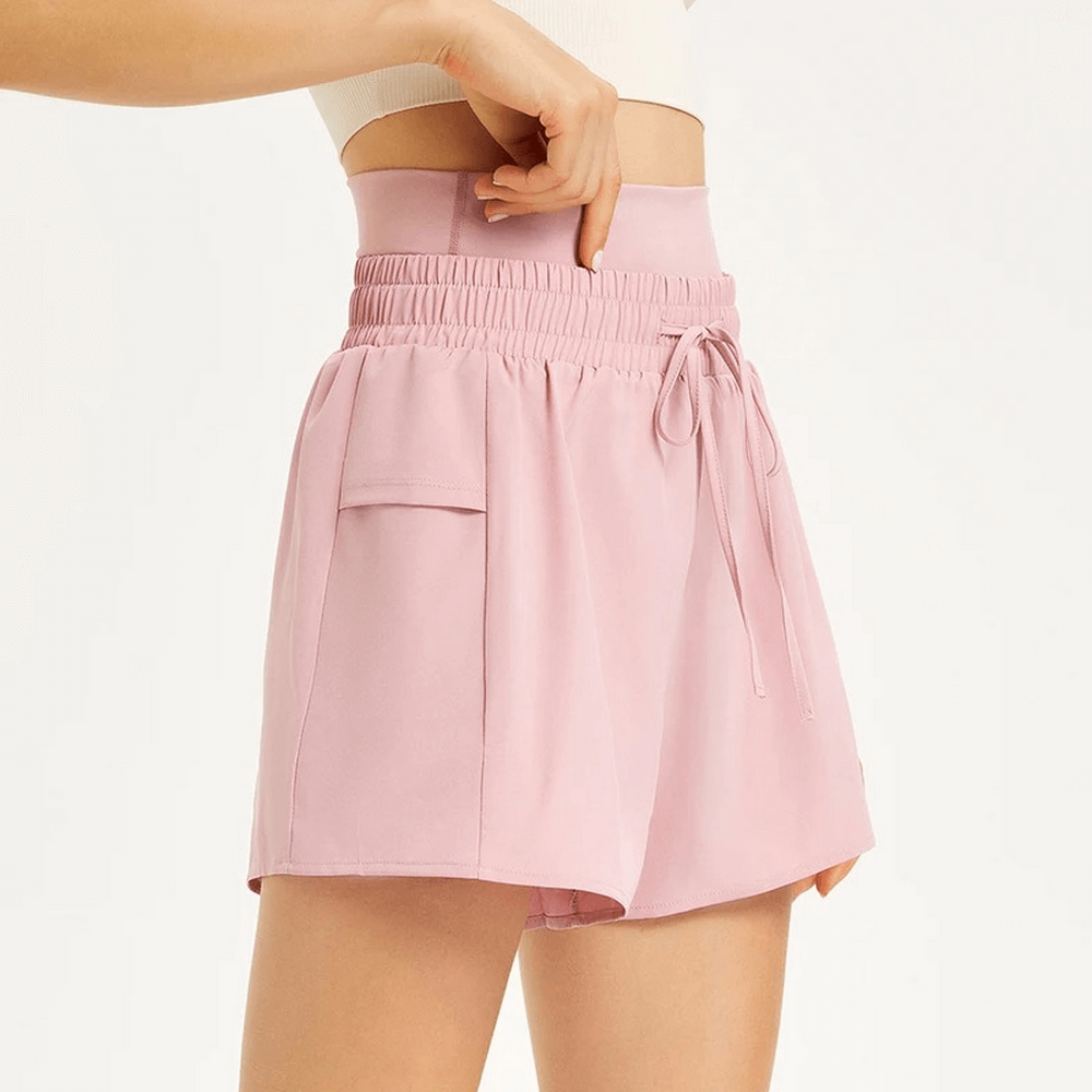 Stylish pink women's casual drawstring athletic shorts with pocket detail, perfect for summer activities and quick-drying comfort.